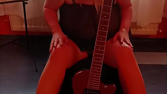 Une Femme Au Foyer Excitée Joue Avec Elle-Même Tout En Pianotant La Guitare